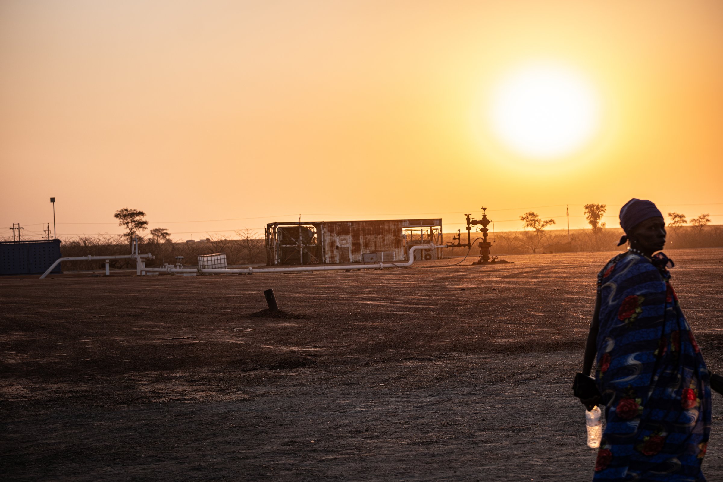 Un puits de pétrole et ses installations techniques émergent au milieu d'une vaste plaine. Des dizaines de sites similaires jalonnent la région. D'ici, le brut est acheminé vers Port-Soudan par le Greater Nile Oil Pipeline. État d'Unité, Soudan du Sud, mars 2026.