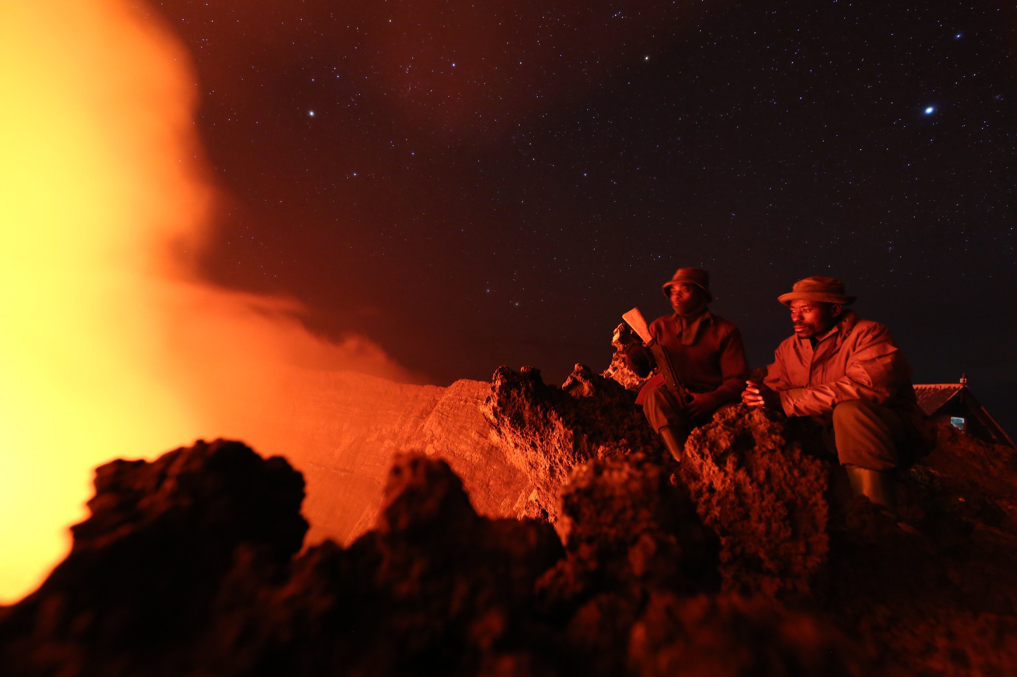 Deux gardes du Parc national des Virunga contemplent la lave du cratère Nyiragongo en 2016.