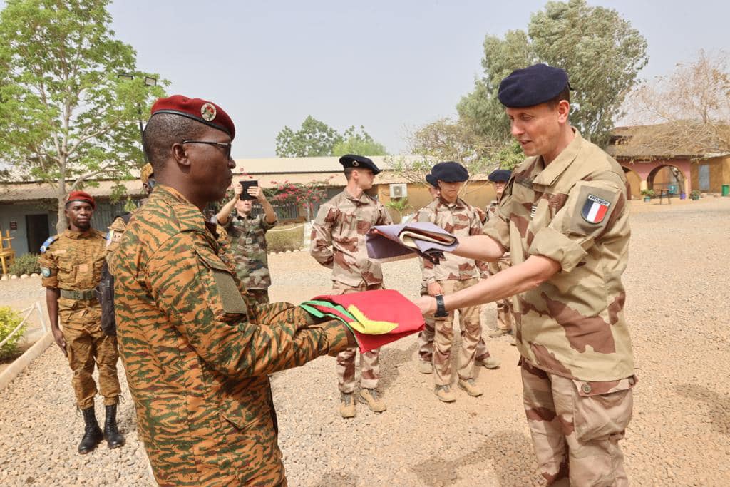 Des officiers des forces burkinabè et françaises lors d'une cérémonie de descente du drapeau marquant la fin de la présence de la force Sabre au Burkina Faso, le 18 février 2023.