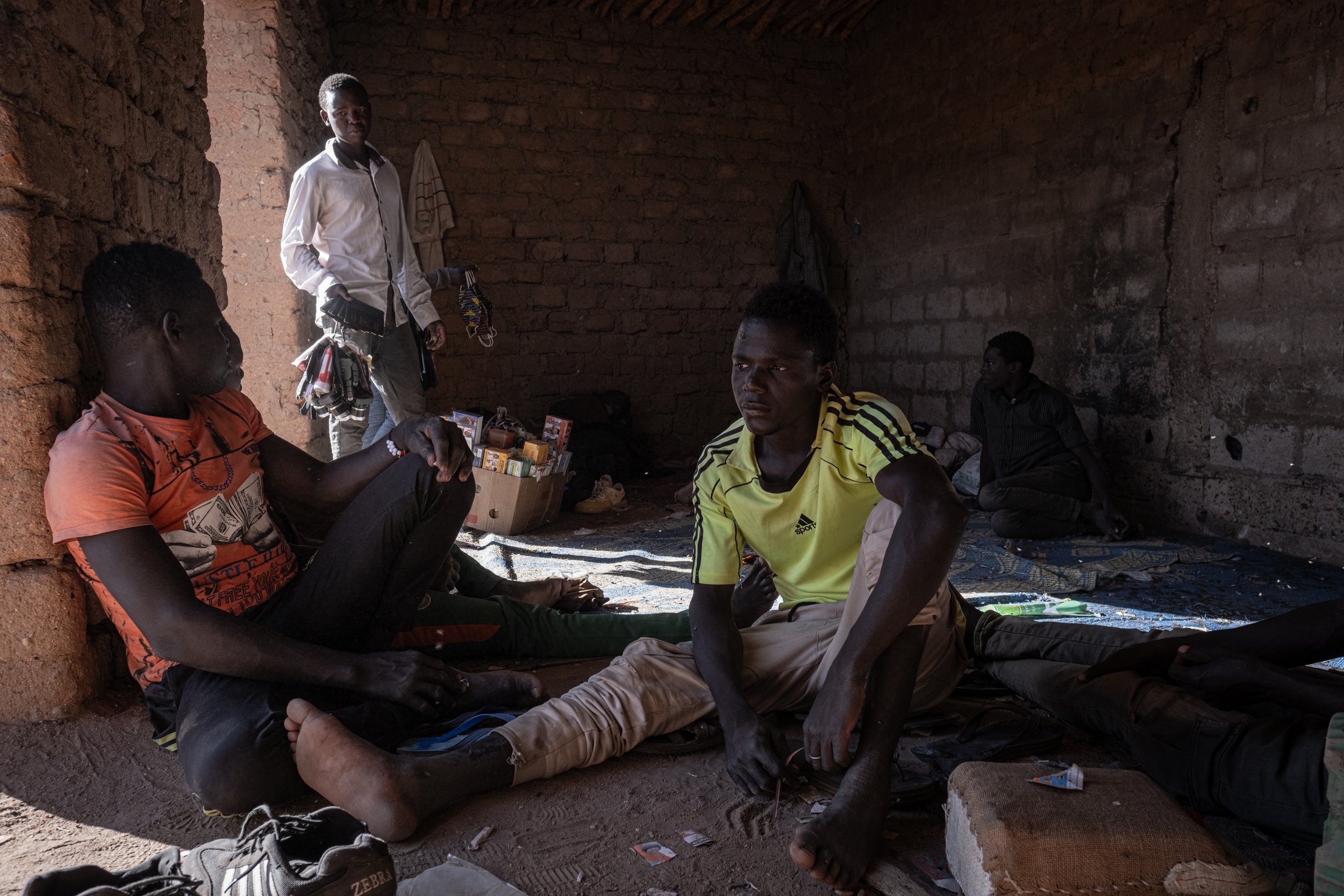 Un groupe de jeunes migrants attend de partir dans un garage où des camionnettes sont préparées dans les environs de la gare centrale d'Agadez.