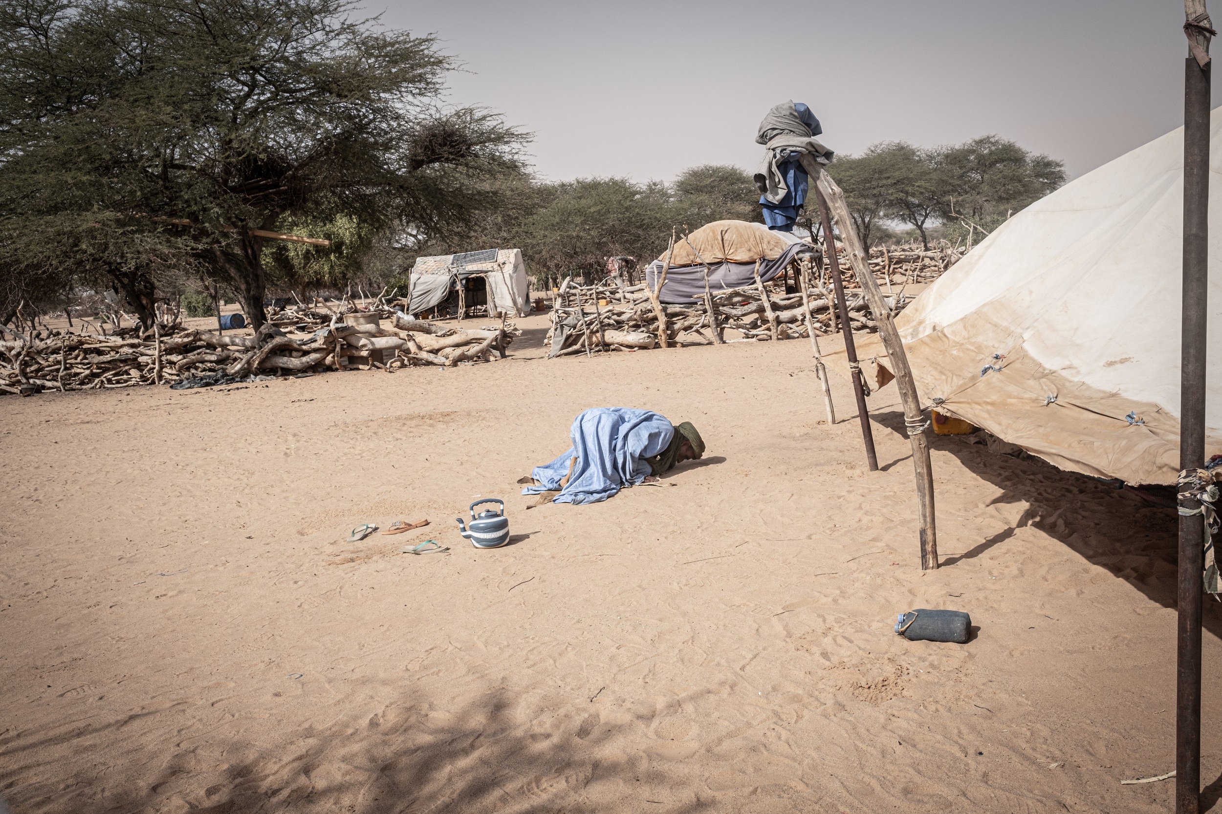 Un homme prie à côté d'une tente dans un village situé le long de la frontière avec le Mali, dans la région du Hodh Ech Chargui (11 novembre 2023).