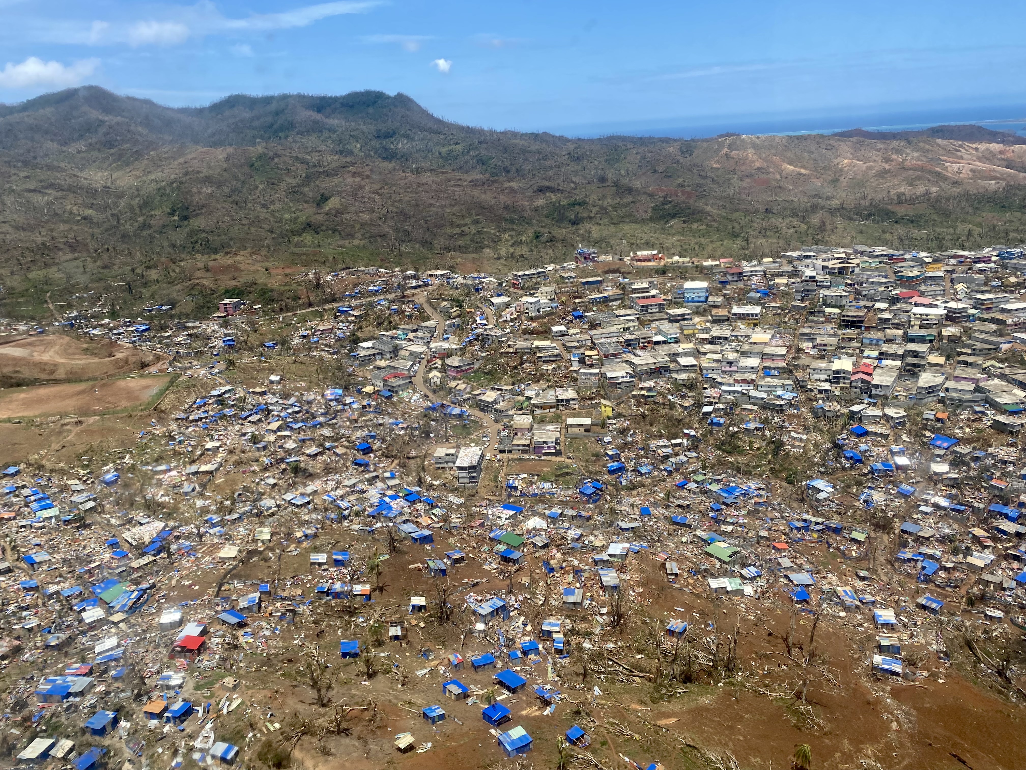 Bidonville de Tsoundzou vu du ciel, une semaine après le passage du cyclone. Certains habitats sont reconstruits avec de la tôle et protégés par des bâches bleues.