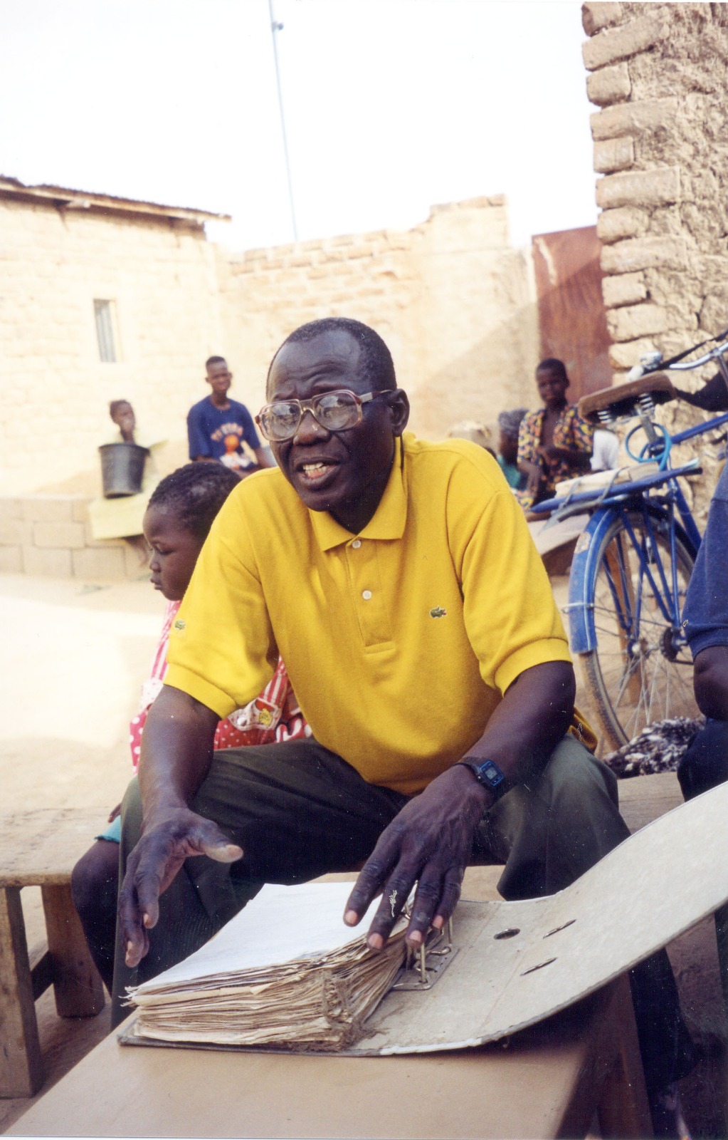 Souleymane Guengueng, rescapé des prisons, à son domicile de N'Djamena, au Tchad, en 2001. Devant lui, certains des 792 dossiers qu'il a établis sur les victimes de Habré.