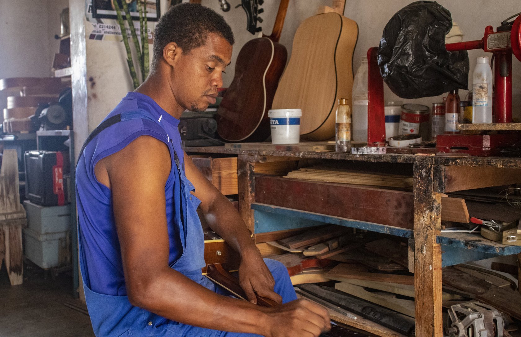 Romer travaille tous les jours à l'atelier. Il est formé par Aniceto Gomes et construit différents instruments à cordes.