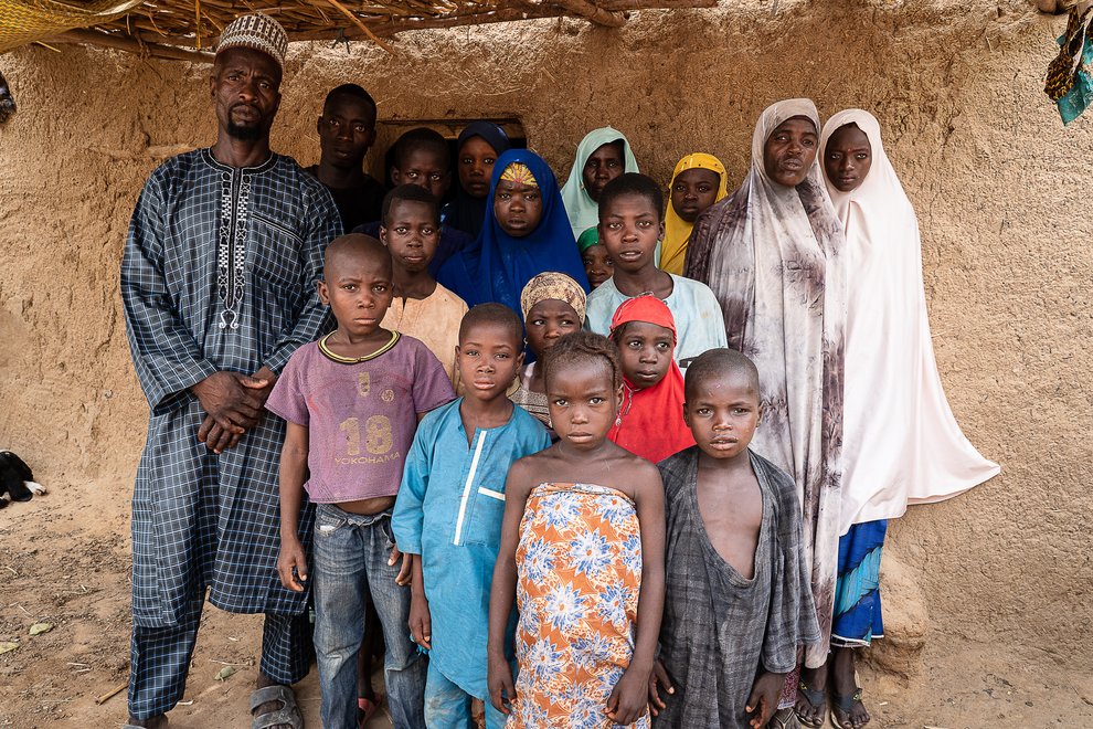 Issa Yahaya (à gauche) entouré de ses deux épouses et de leurs enfants, à Kataguiri, le 7 mai 2022.