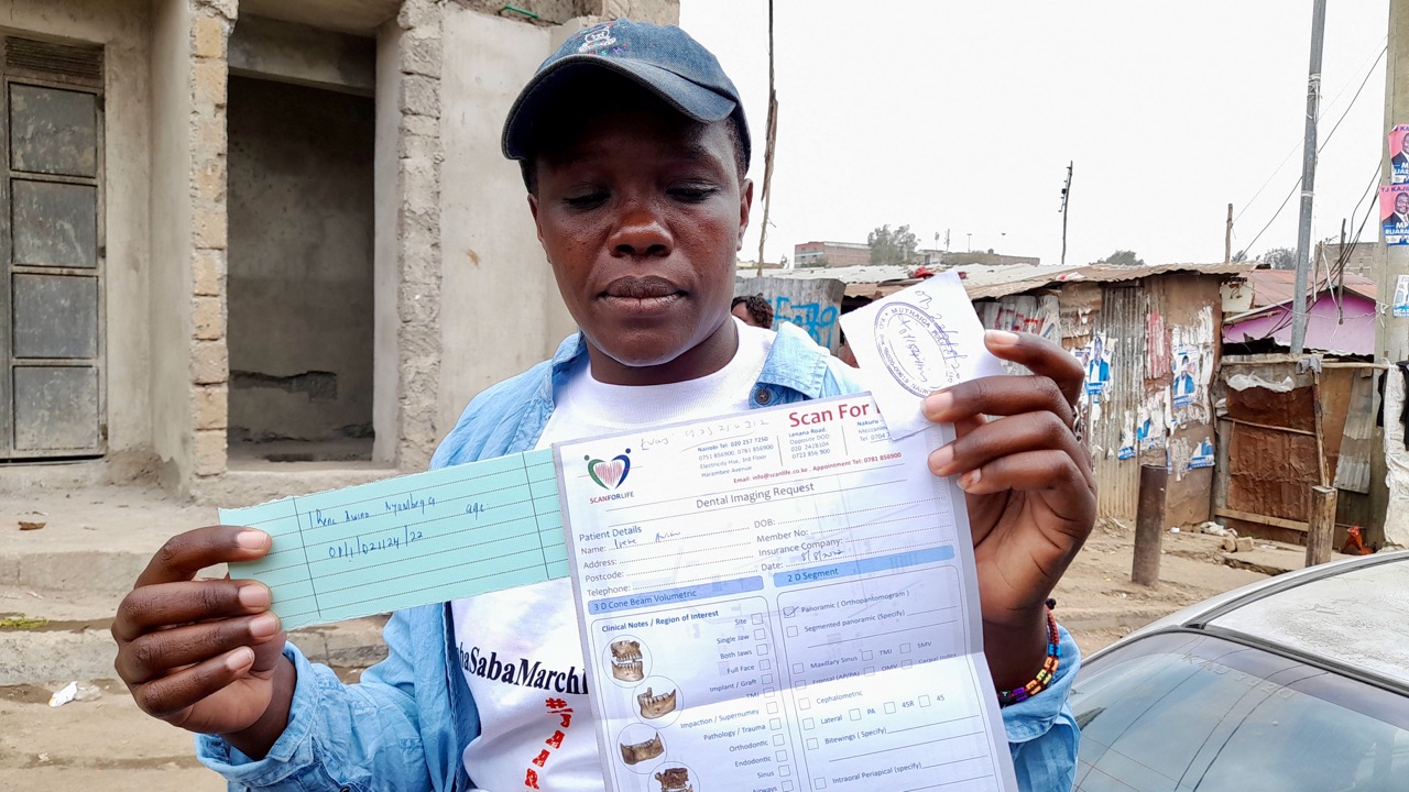 Irene Nyambega, victime de violences lors des élections de 2022, montre les formulaires de plainte qu'elle a soumis à la police.