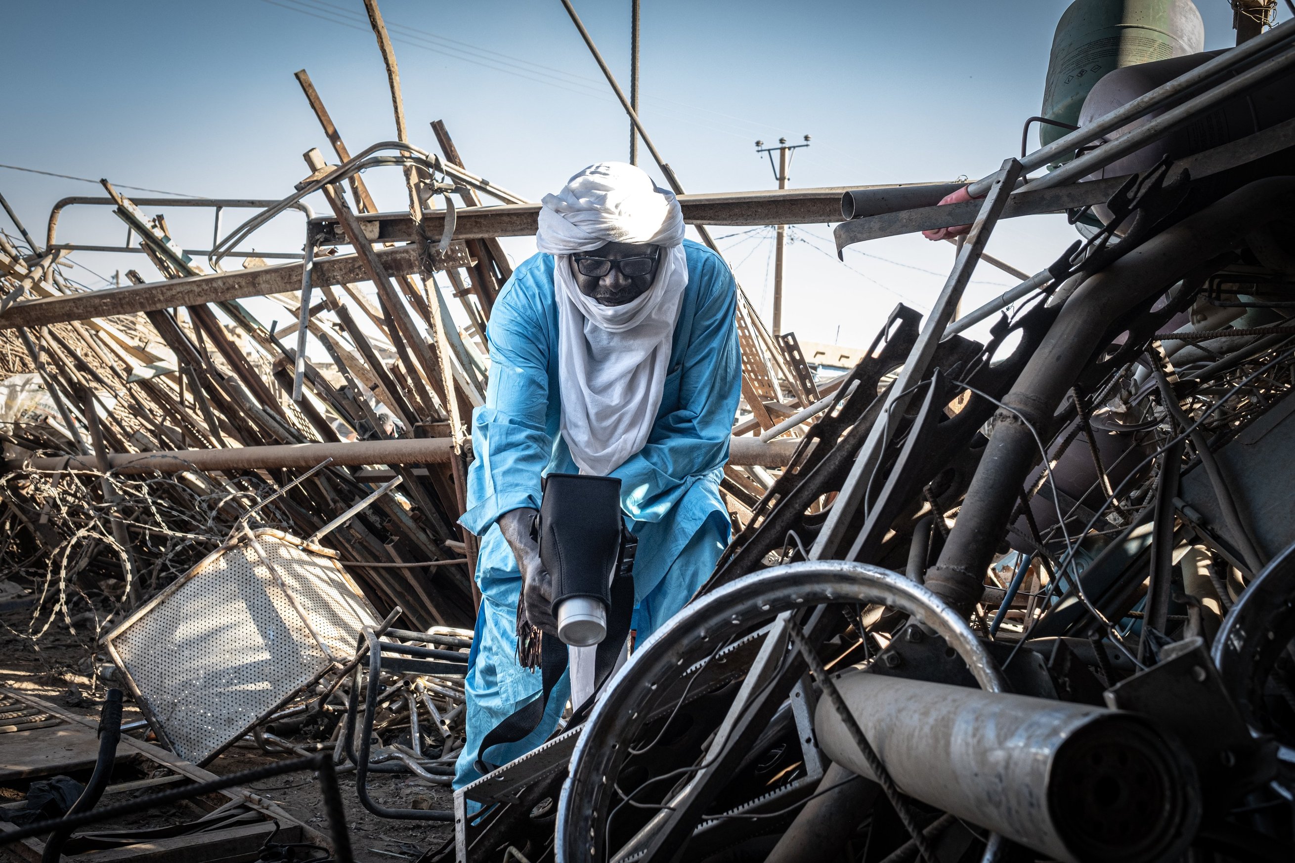 Almoustapha Alhacen utilise le scintillomètre pour mesurer la radioactivité de la ferraille, à Arlit.