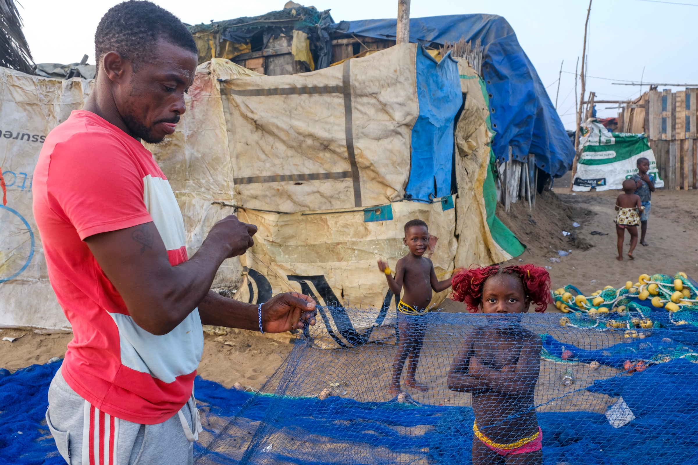 Un pêcheur du quartier de Katanga répare les mailles de son filet (2025).