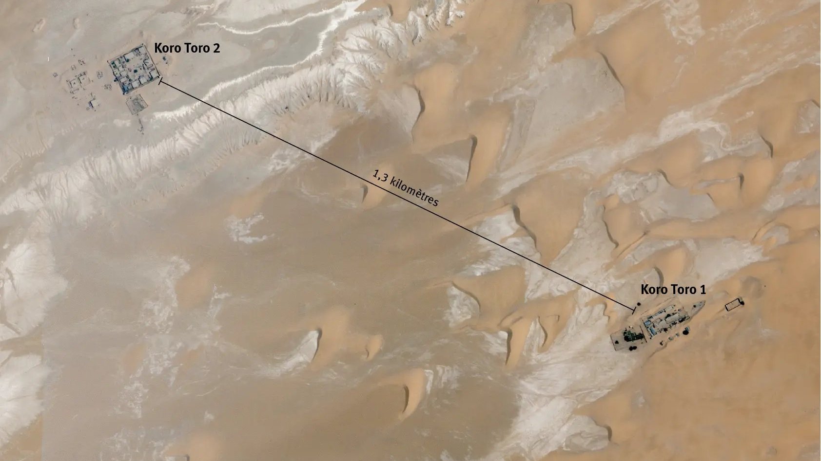 Cette image est une carte satellite des deux sites de la prison de Koro Toro, situés dans la région de Borkou au Tchad. On voit une étendue désertique avec des dunes de sable clair et des zones rocheuses. Les deux complexes de la prison, désignés comme Koro Toro 1 et Koro Toro 2, sont indiqués par des marqueurs. Koro Toro 2 est situé à l'ouest, tandis que Koro Toro 1 se trouve à l'est, séparés par une distance d'environ 1,3 kilomètre. En bas de l'image, il y a une échelle qui montre que la distance totale est de 200 mètres, et une orientation indiquant le nord. L'image a été prise le 4 mai 2023.