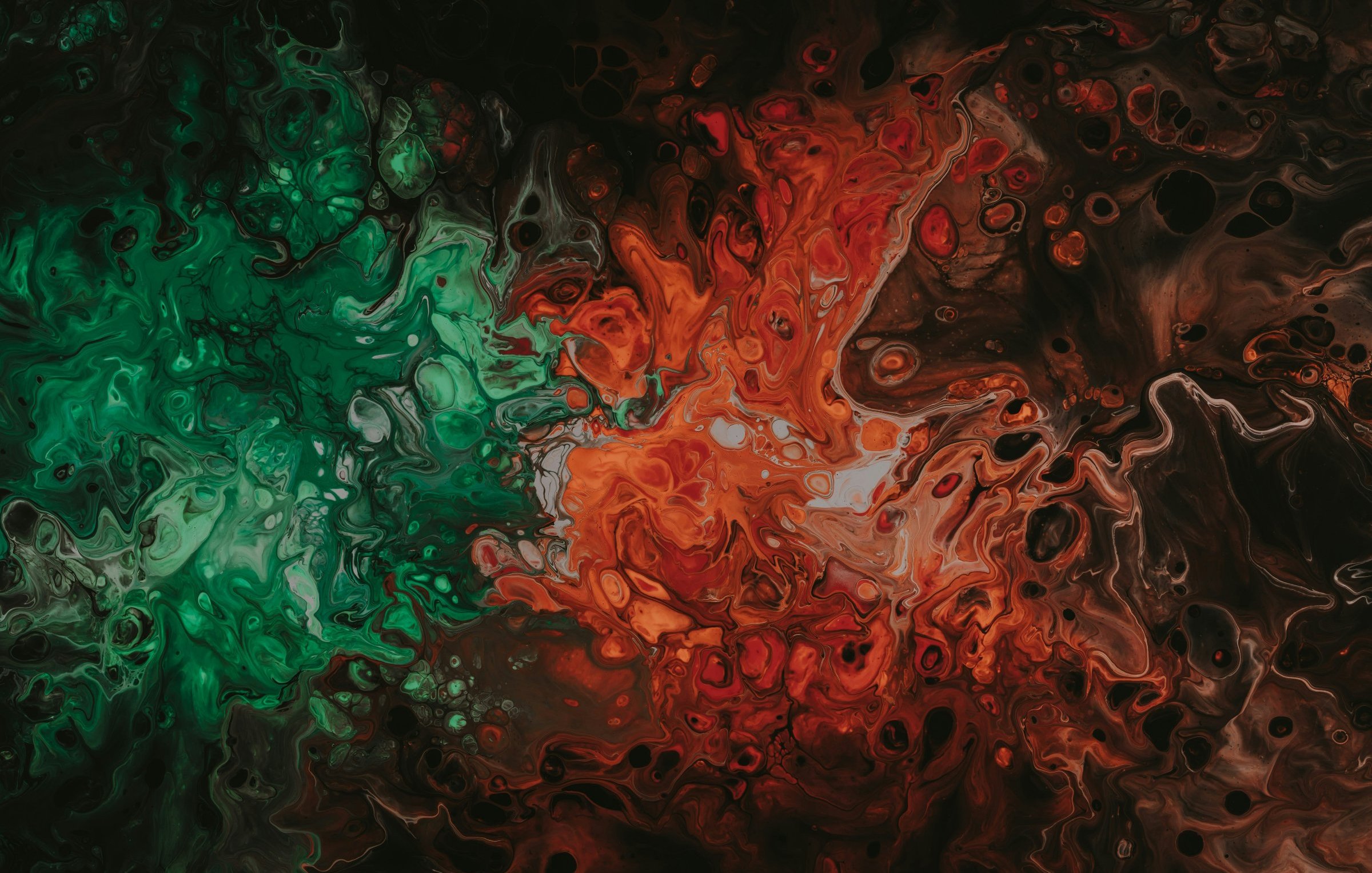 L'image présente une composition abstraite aux teintes vives et contrastées. On y observe principalement des zones de couleurs vertes et rouges, qui se mélangent et tourbillonnent de manière organique. Les nuances varient du vert intense au rouge profond, créant une dynamique visuelle qui évoque une sensation de mouvement et de fluidité. Les formes semblent onduler, comme si elles étaient remplies de matière liquide, donnant l'impression d'une danse entre les couleurs sur un fond sombre et mystérieux, presque noir. Cette œuvre évoque une ambiance à la fois fascinante et tumultueuse, invitant à l'imagination et à la contemplation.