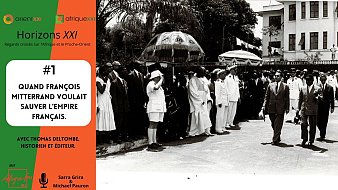 L'image présente un groupe de personnes marchant dans une rue, habillées en vêtements d'époque, probablement vers les années 1960. Au premier plan, on voit un homme en costume sombre, entouré de plusieurs autres personnes en costumes blancs et uniformes. À l'arrière-plan, on aperçoit des bâtiments majestueux, ainsi que des arbres feuillus, ajoutant une touche d'élégance à la scène. Certains membres du groupe tiennent des chapeaux ou des ombrelles pour se protéger du soleil. Dans le coin supérieur gauche, on trouve le nom de l'événement ou de la thématique : "Horizons XXI", avec des éléments graphiques en orange. L'image évoque un moment historique où François Mitterrand, alors homme politique, cherchait à préserver l'influence de la France dans ses anciennes colonies. Cette scène représente une époque marquée par des enjeux politiques et historiques complexes.