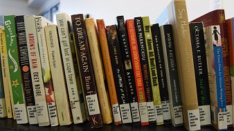 L'image montre une étagère remplie de livres disposés de manière ordonnée. Chaque livre a une couverture colorée, avec des titres variés, allant de l'écriture en noir sur fond blanc à des couleurs vives. Les tranches des livres portent des étiquettes blanches avec des chiffres, semblant indiquer des références ou des catégories. Les livres semblent être principalement de la fiction et abordent divers thèmes, suggérant un éventail d'histoires et de genres littéraires. L'ambiance générale est celle d'une bibliothèque ou d'un espace de lecture, invitant à la découverte littéraire.