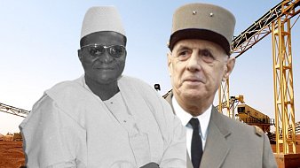 L'image montre deux figures importantes de l'histoire. À gauche, on voit un homme portant une tenue traditionnelle, avec une chemise blanche et un chapeau. Il a une expression sereine. À droite, un homme en uniforme militaire, avec un chapeau distinctif, regardant vers l'objectif. L'arrière-plan est composé d'une infrastructure industrielle, peut-être des machines ou des bâtiments, qui évoque un cadre de développement économique. L'ensemble de l'image semble évoquer une rencontre entre deux cultures ou époques différentes.