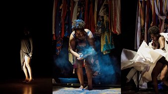 L'image présente une scène de performance artistique en trois parties. À gauche, on voit une silhouette sombre d'une danseuse, légèrement éclairée, qui se tient debout, les jambes nues, suggérant une posture pensive ou introspective. Au centre, une autre danseuse est en action, entourée de fumée, en train de manipuler des objets, évoquant une intensité émotionnelle et une interaction avec l'espace. Enfin, à droite, la danseuse semble déchirer des morceaux de tissu, exprimant un mouvement dynamique et presque chaotique. En arrière-plan, une tapisserie colorée de tissus suspendus ajoute une texture visuelle riche et un contraste vibrant à la scène sombre. L'ensemble crée une atmosphère à la fois intime et expressive, transmettant des émotions variées à travers le mouvement et la présence corporelle.