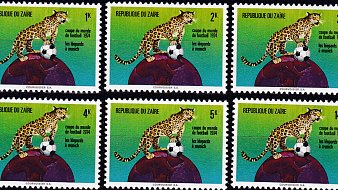 L'image présente une série de timbres-poste provenant de la République du Zaïre, commémorant la Coupe du Monde de football de 1974. Chaque timbre montre un léopard, symbole national, en position fière, perché sur un globe terrestre. Le léopard semble prêt à bondir, et le globe est entouré de couleurs vives, allant du vert au bleu. Les timbres affichent des valeurs différentes : 1K, 2K, 3K, 4K, 5K et 14K, tous ornés de la même illustration, avec le titre "RÉPUBLIQUE DU ZAÏRE" en haut. La scène évoque une célébration du sport et de la fierté nationale, tout en mettant en avant le rôle du football dans la culture.