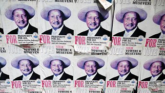 L'image montre un collage de plusieurs affiches sur un mur. Chaque affiche présente le même portrait d'un homme portant un chapeau de paille. Il a un grand sourire et affiche une expression confiante. Sous son image, on peut lire des textes en lettres majuscules qui soulignent des mots comme "PROSPERITY" (prospérité) et "FOR" (pour). Les affiches semblent faire partie d'une campagne politique, faisant appel au soutien des électeurs. Le fond est en papier décoloré et usé, indiquant que ces affiches ont été exposées pendant un certain temps.