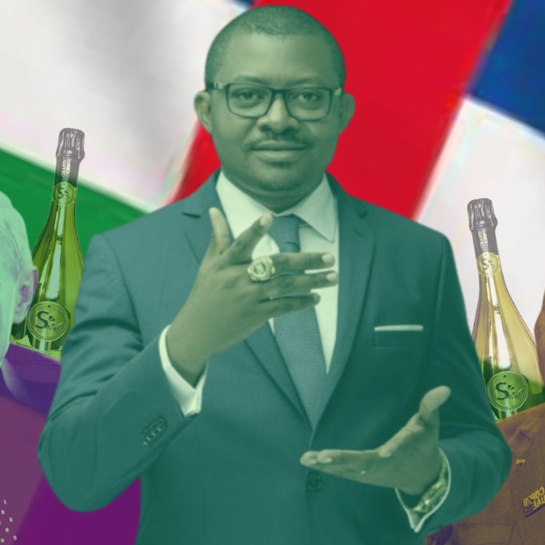 L'image présente un collage coloré. Au centre, un homme en costume sombre fait un geste de la main, semblant s'adresser au public. À gauche, une silhouette qui semble représenter un homme avec des traits distinctifs, accompagné de bouteilles alignées. À droite, une autre figure masculine, également entourée de bouteilles. En arrière-plan, on peut distinguer des motifs de drapeaux, avec des couleurs vives qui créent un contraste. L'ensemble évoque un thème de pouvoir et de conflit, avec des références symboliques aux leaders et à la richesse.