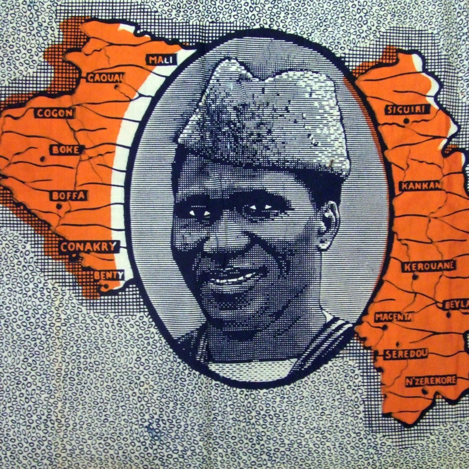 L'image que vous décrivez se compose principalement d'une carte stylisée de la Guinée, avec des contours et des noms de différentes régions. Au centre, il y a un portrait en noir et blanc d'un homme souriant, qui porte un chapeau caractéristique. Ce portrait est entouré d'un cadre ovale, et l'ensemble est mis en valeur par des zones colorées en orange sur la carte, qui semblent indiquer des localités spécifiques. Le fond est constitué de motifs répétitifs, créant une texture visuelle intéressante. Cette image évoque une célébration de la culture guinéenne, mettant en avant à la fois la géographie et une personnalité marquante.