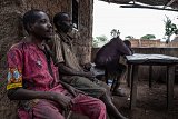 Un groupe d'agriculteurs de l'ethnie wama se repose devant une taverne, dans le village de Wansokou, après une dure journée de travail dans les champs.