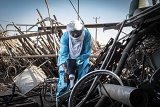 Almoustapha Alhacen utilise le scintillomètre pour mesurer la radioactivité de la ferraille, à Arlit.