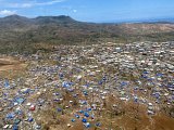 Bidonville de Tsoundzou vu du ciel, une semaine après le passage du cyclone. Certains habitats sont reconstruits avec de la tôle et protégés par des bâches bleues. 