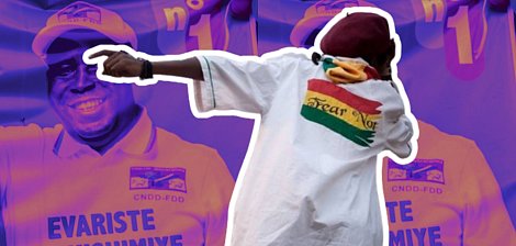 The image features a figure wearing a white shirt with vibrant colors and a design on the back. The background includes repeated images of a man, possibly a political figure, smiling and wearing a hat with a logo. The overall color scheme is purple, enhancing a dynamic atmosphere. The shirt's imagery suggests a message of confidence or defiance.